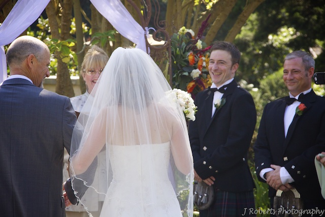 Groom greeting bride down the aisle - wedding photography